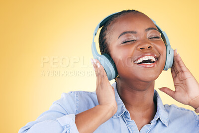 Buy stock photo Singer, music and black woman on headphones, smile and listening in studio isolated on a yellow background. Excited, radio and African person streaming podcast, audio and sound, hearing and freedom.