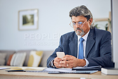 Buy stock photo Phone, networking and mature businessman in the office typing a text message on social media. Serious, technology and professional male lawyer browsing on the internet with a cellphone in workplace.