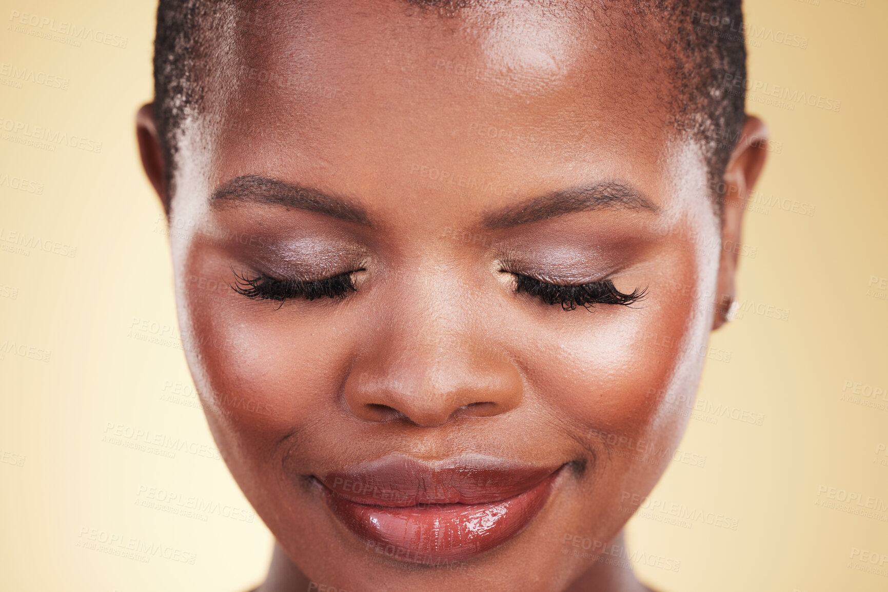 Buy stock photo Makeup, beauty and face of a black woman in studio for self care, skin glow and cosmetics. Closeup of african person or aesthetic model with facial shine and eyelash extension on a beige background