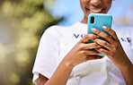 Black woman, phone and hands typing in nature for communication, social media or outdoor networking. Closeup of happy African female person smile in chatting or texting on mobile smartphone app