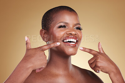 Buy stock photo Teeth, beauty and a woman pointing at smile in studio for skin care, glow or cosmetics. Face of African model person with dental shine, dermatology and makeup announcement on a beige background
