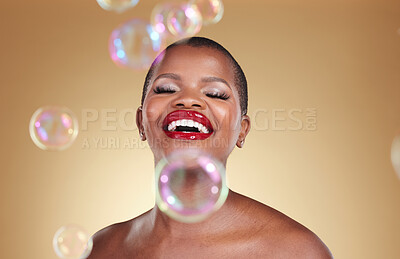 Buy stock photo Cosmetics, makeup and bubbles with face of black woman in studio for beauty, spa treatment and luxury. Skincare, dermatology and self care with model on gold background for glow, facial and soap