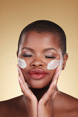 Buy stock photo Face, cream and beauty of black woman in studio for self care, skincare or cosmetics. Headshot of african person or aesthetic model with facial moisturizer, dermatology and glow on a beige background