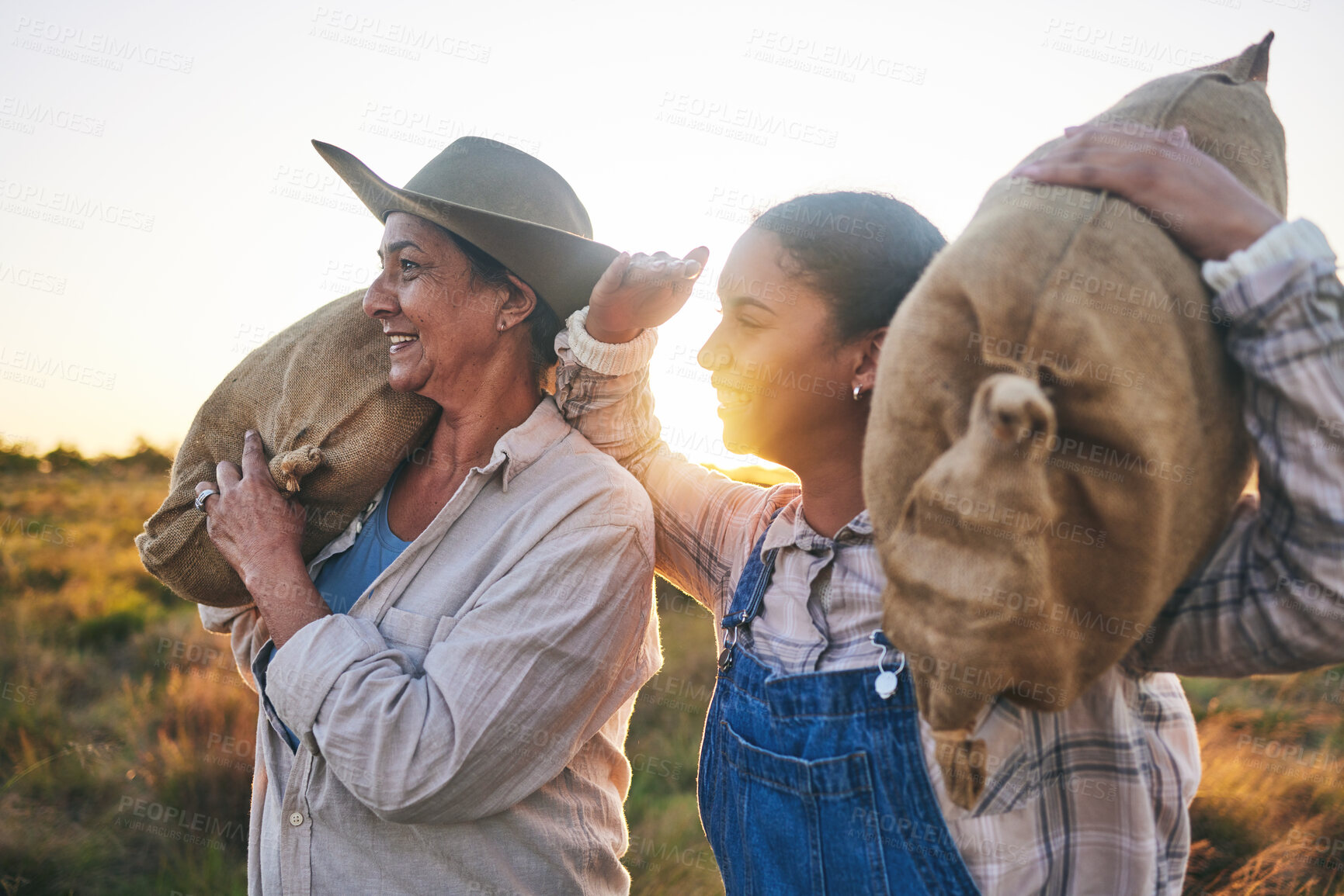 Buy stock photo Farm harvest, women and countryside with a smile from working on a grass field with grain bag. Sustainability, eco friendly and agriculture outdoor at sunset in nature with farmer management mission