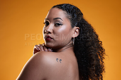 Buy stock photo Beauty, portrait and a woman with a tattoo in studio for cosmetics, makeup and dermatology. Closeup of a young female model on an orange background in studio with body art, confidence and skin glow