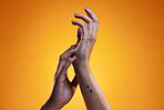 Hands, touch and skin care of a woman in studio with dermatology cosmetics and a manicure. Beauty salon, spa and a person on an orange background for wellness, health and clean body or hygiene