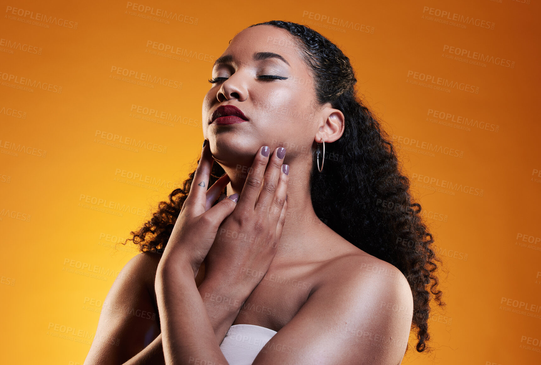 Buy stock photo Beauty, makeup and curly hair with face of woman in studio for texture, fashion and cosmetics. Self care, salon and hairstyle with model on orange background for skincare, spa treatment and mockup