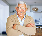 Senior man, portrait and retirement house with arms crossed and smile from elderly care. Confidence, relax and living room room with male person from Mexico with glasses and happy in a old age home
