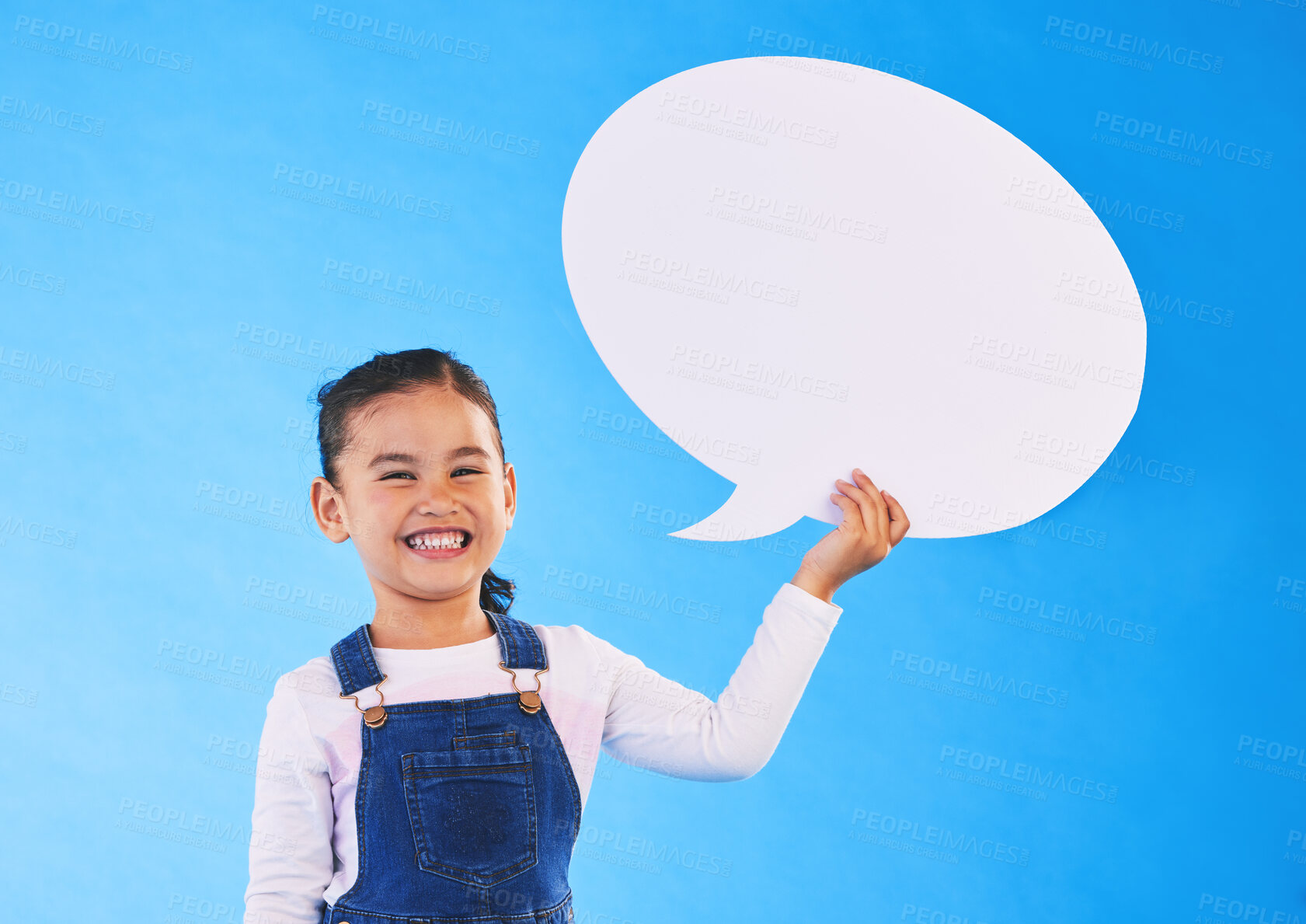 Buy stock photo Girl child, speech bubble and studio portrait for smile, mockup space and excited by blue background. Female kid, paper billboard and happy for news, info and promo of deal, discount and social media