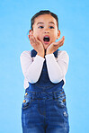 Shocked, wow and girl with hands to face in studio with fear and scared from danger. Alarm, blue background and young child from Hawaii with scary, omg surprise and emoji face of a kid in danger