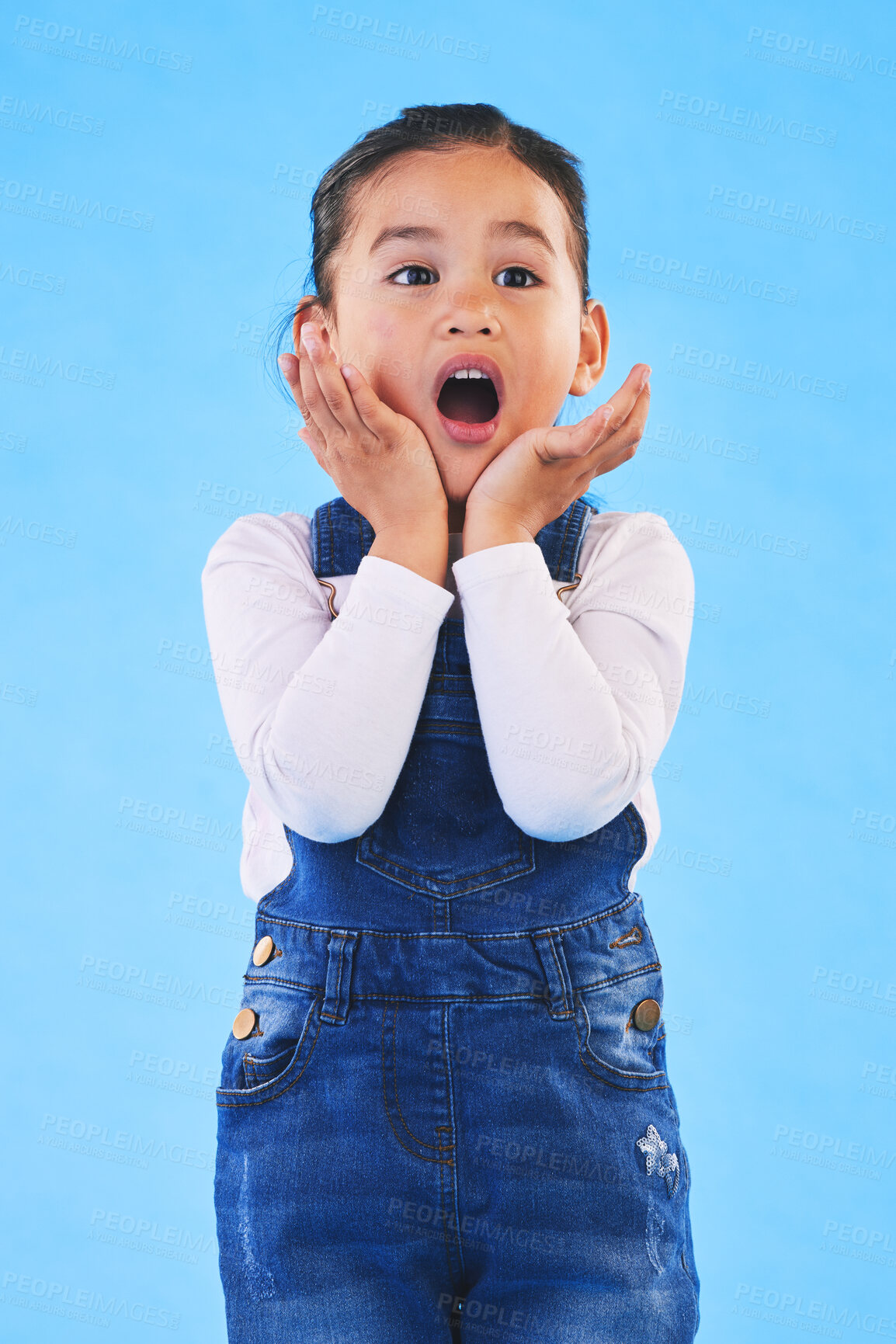 Buy stock photo Shocked, wow and girl with hands to face in studio with fear and scared from danger. Alarm, blue background and young child from Hawaii with scary, omg surprise and emoji face of a kid in danger