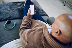 Phone screen, mockup and a man on a home sofa for internet advertising with social media or a website. Behind a person with a smartphone and blank space for network, streaming music and headphones