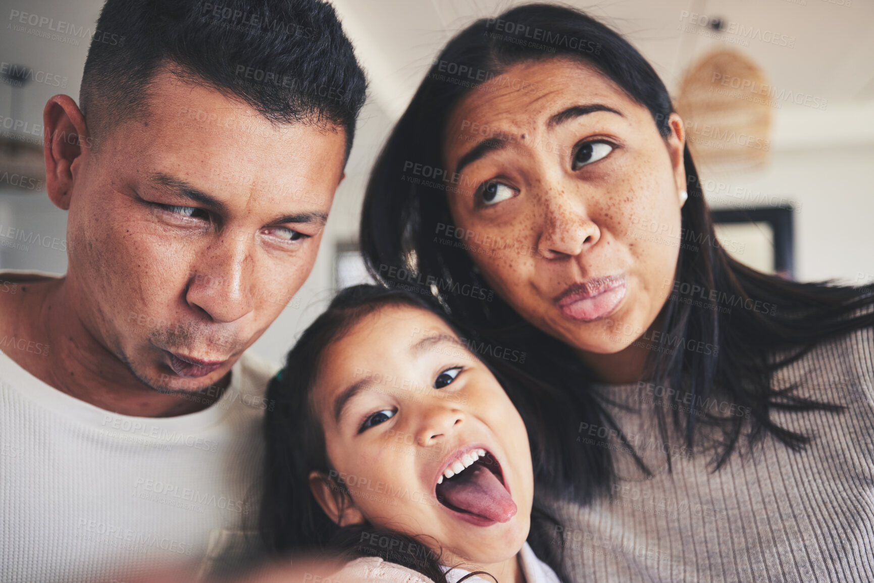 Buy stock photo Selfie, silly and portrait of girl with her parents bonding in the living room of their home. Goofy, happy and child taking a picture with her mother and father with funny faces at their family house