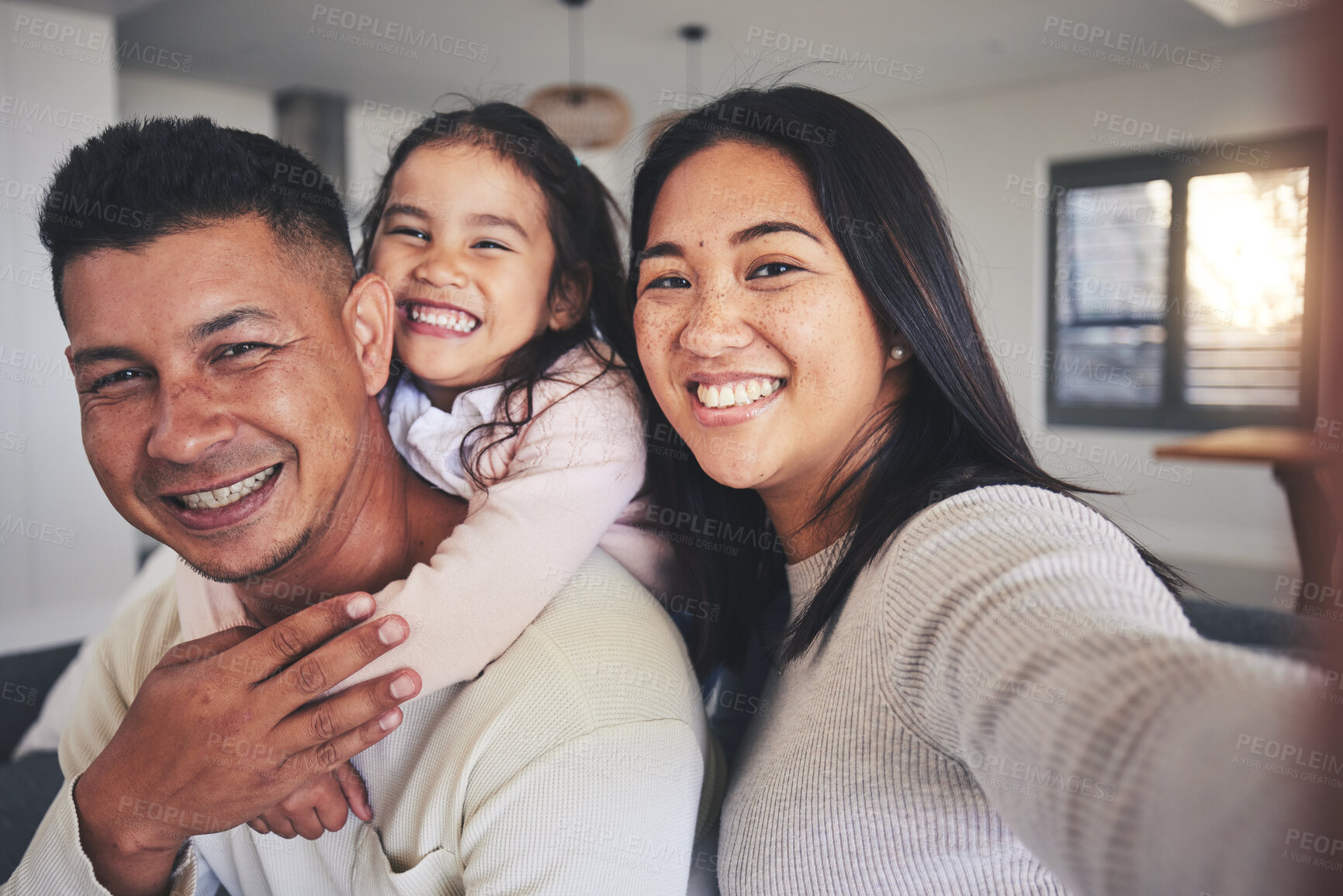 Buy stock photo Selfie, happy and portrait of a family with a smile bonding in the living room of their home. Together, love and young happy parents taking a picture with their sweet girl child for memories in house