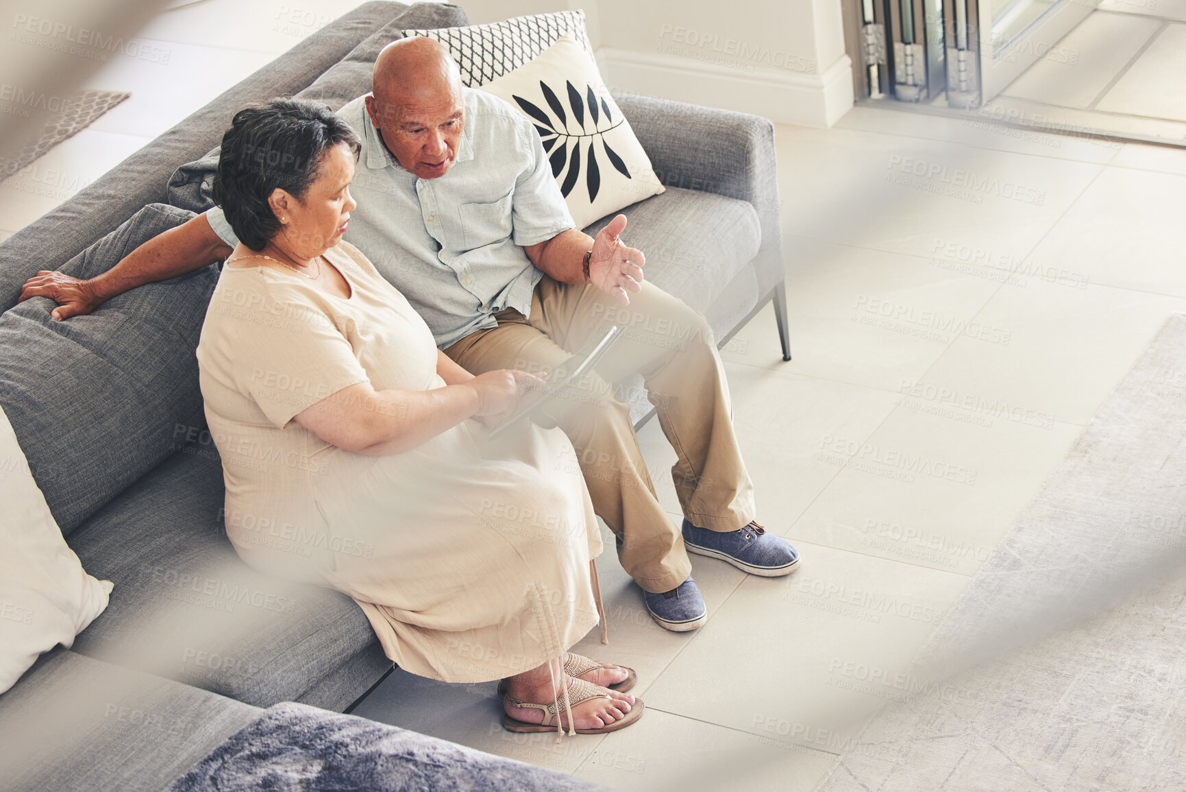 Buy stock photo Senior, tablet and frustrated couple search online on couch together online or internet with stress and angry. Conversation, web and elderly people streaming on sofa annoyed at service on retirement