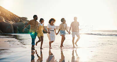 Buy stock photo Happy, holding hands and sunset with friends at beach for freedom, support and travel. Wellness, energy and summer  with group of people walking by the sea for peace, adventure and vacation together