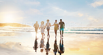 Buy stock photo Friends, together and walking on beach at sunset in water in summer, vacation or holiday break with freedom. Group, silhouette and people with connection, holding hands and support in community