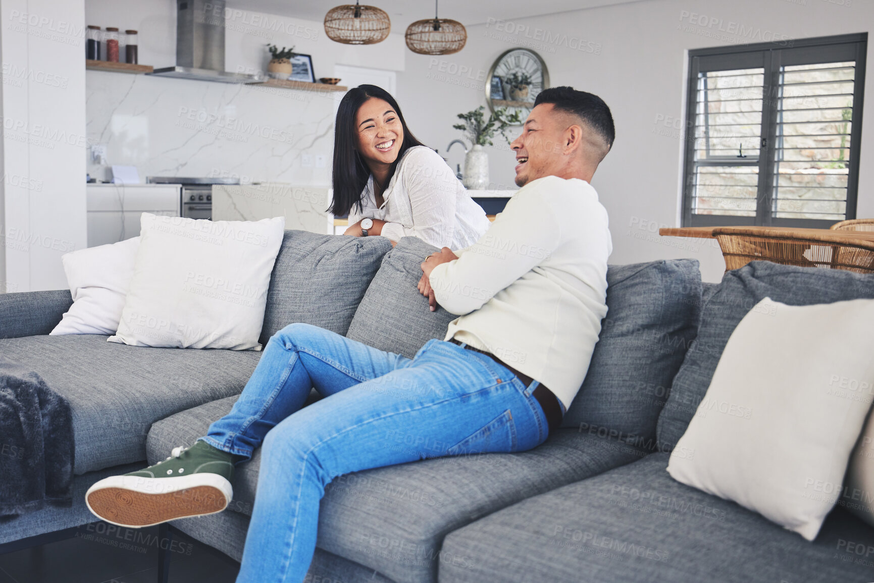 Buy stock photo Happy, love and couple relax on a sofa bond, talking and enjoying weekend in their home together. Smile, conversation and woman with man in living room, laugh and having fun, speaking and chilling 