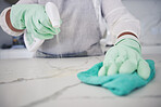 Person, hands and cleaning table with spray bottle, detergent or bacteria or germ removal at home. Closeup of housekeeper, maid or cleaner wiping surface with cloth in clean hygiene or sanitize house