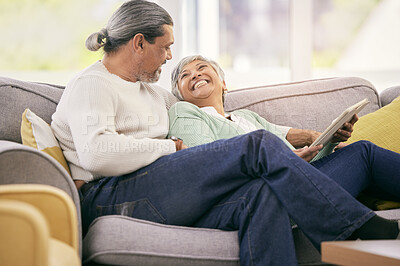 Buy stock photo Happy, mature couple and tablet on sofa to relax with streaming a funny, comedy show or movie together in lounge. Love, man and woman in retirement laughing with mobile app or conversation in home