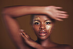 Art, portrait of black woman with gold makeup and blurred background, glitter paint and cosmetics. Shine, glow and African model in studio for beauty, fashion and aesthetic freedom in luxury skincare