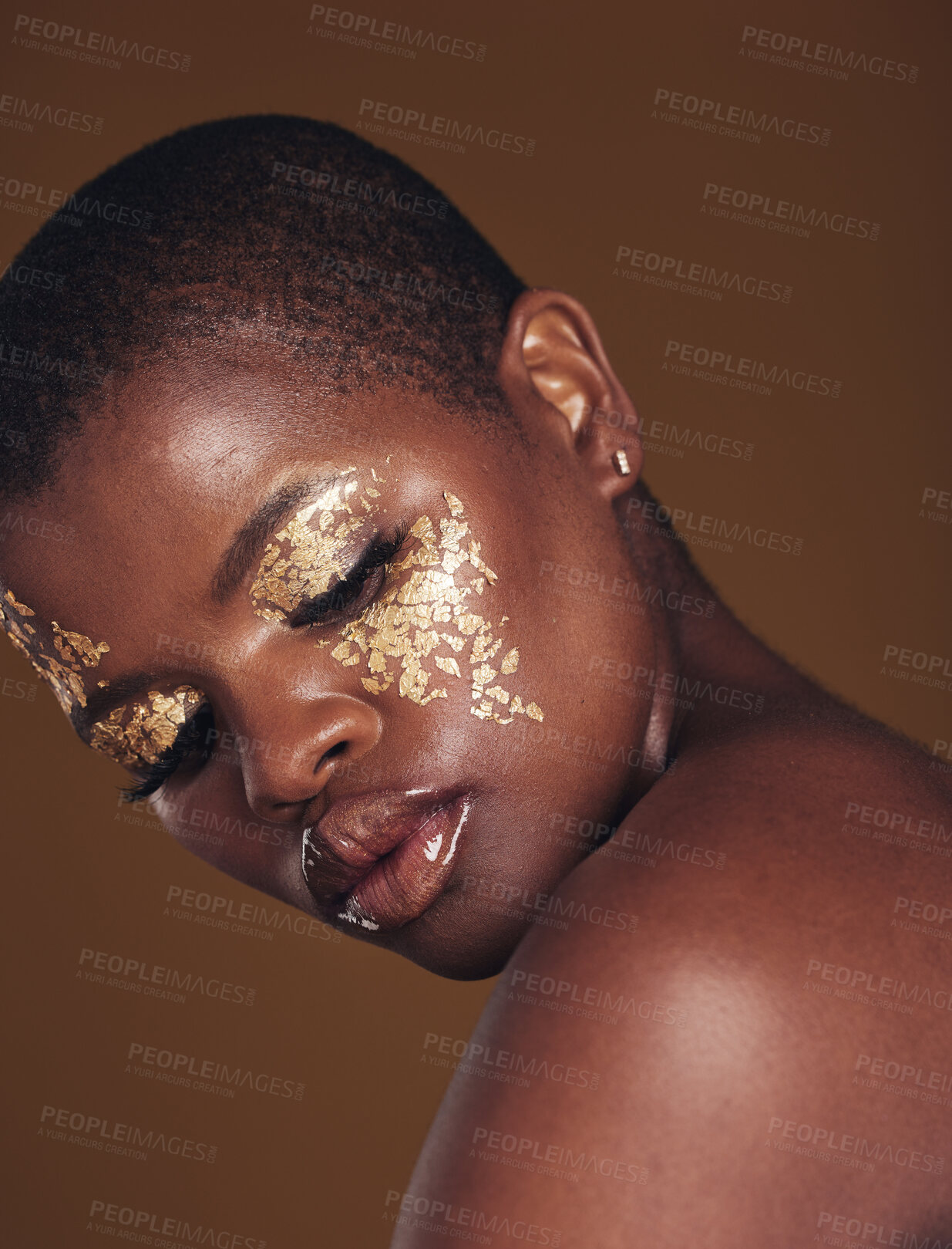 Buy stock photo Art, glitter and black woman with gold makeup on brown background, face paint and cosmetics. Shine, glow and African model in studio for beauty, fashion and aesthetic freedom in luxury skincare.