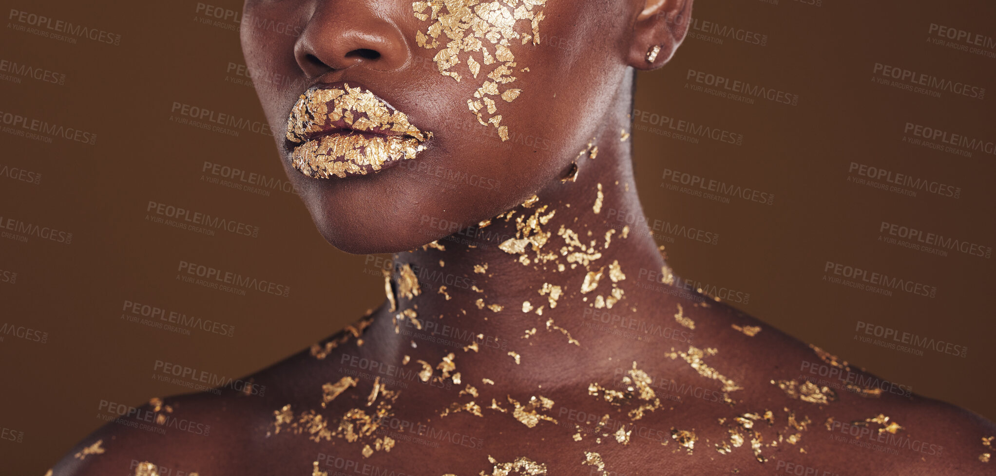 Buy stock photo Beauty, lips and black woman with gold makeup on brown background for art, cosmetics and glitter paint. Shine, glow and zoom on model mouth for aesthetic luxury, skincare and metal lipstick in studio