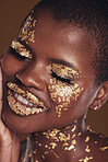 Black woman, face and gold cosmetics closeup with luxury dermatology and skincare mask with glitter. Sparkle, smile and beauty with rich and shine of makeup and model in a studio with facial art