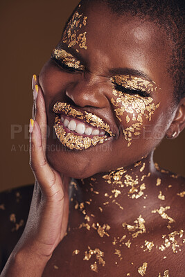 Buy stock photo Black woman, silly face and gold makeup with luxury dermatology and skincare mask with glitter. Sparkle, smile and beauty with rich and shine of cosmetics and model in a studio with facial art