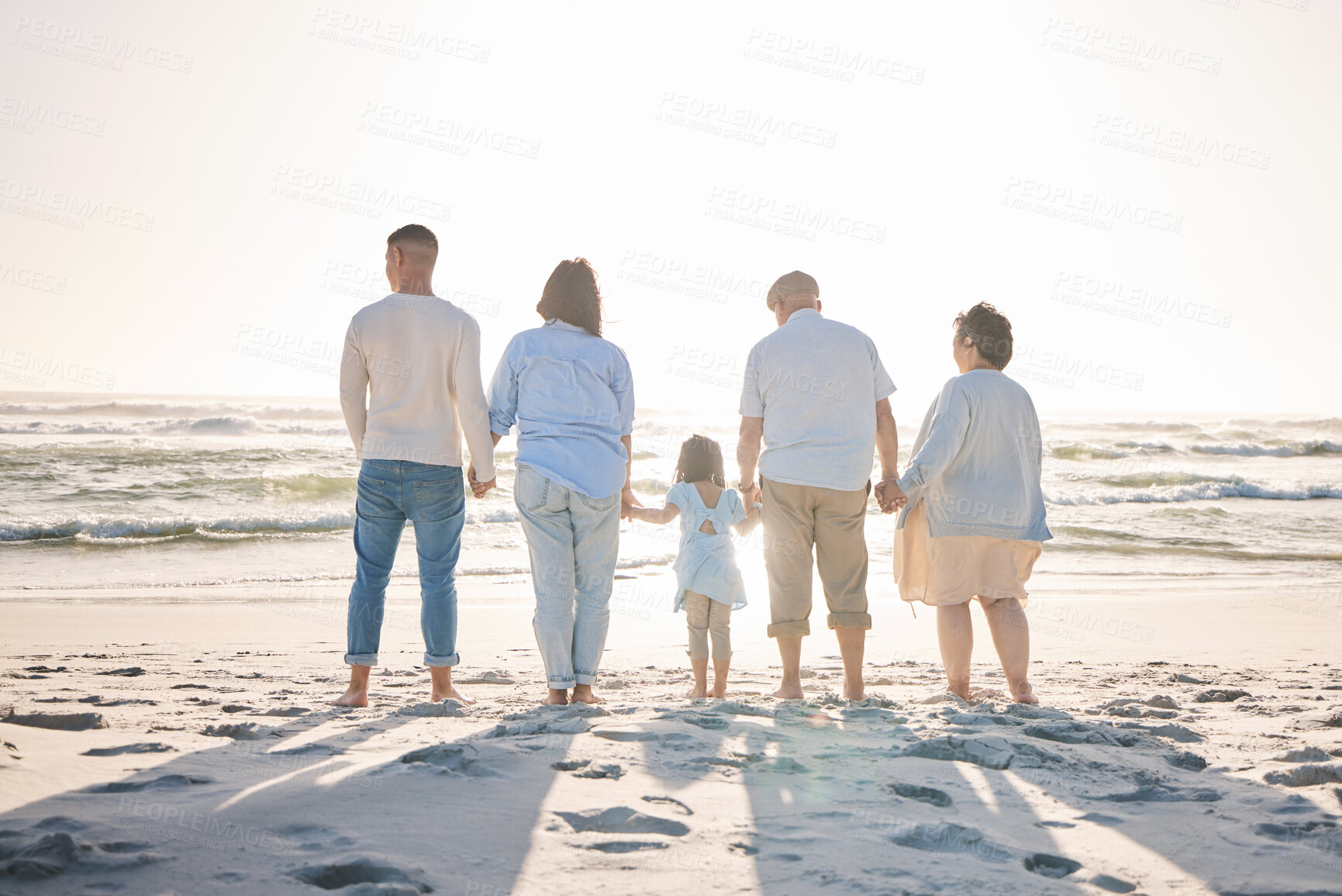 Buy stock photo Summer, relax and holding hands with big family on beach for vacation, bonding and love. Freedom, care and travel with group of people walking at seaside holiday for generations, happiness and mockup