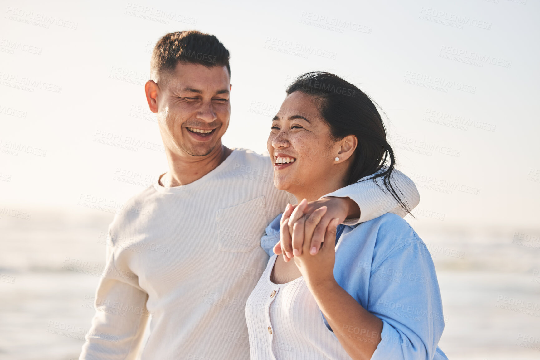 Buy stock photo Love, smile and hug with couple at beach for travel, summer vacation and romance together. Happy, relax and bonding with man and woman walking on seaside holiday for care, date and honeymoon