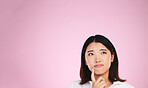 Asian woman, thinking and mockup space in solution, memory or ideas against a pink studio background. Female person in problem solving, wonder or contemplation and reminder, idea or plan on mock up