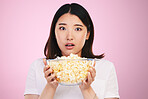 Movie, popcorn and portrait of woman with surprise, horror and bowl or food for watching tv, movies with shock. Wow, face and scared Asian model on pink background in studio with film snack 