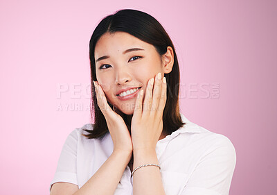 Buy stock photo Beauty, smile and hands on woman face in studio for self love, promotion and care on pink background. Happy, portrait and confident Japanese female model with acceptance, satisfaction and positivity