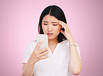 Search, phone and stress with face of woman in studio for networking, communication and worry. Social media, news and frustrated with asian person on pink background for technology and mobile app