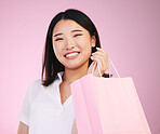 Woman, shopping bag and retail, customer in portrait with purchase and smile isolated on pink background. Gift, store or boutique discount with fashion, commerce and happy, market and sale in studio