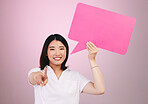 Asian woman, speech bubble and pointing to you on mockup space in choice against a pink studio background. Portrait of female person shape, icon or symbol in decision, selection or vote on mock up