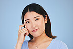 Portrait, thinking and Asian woman with ideas, solution and problem solving on a blue studio background. Face, Japanese person and model with a question, emoji and mockup space with brainstorming