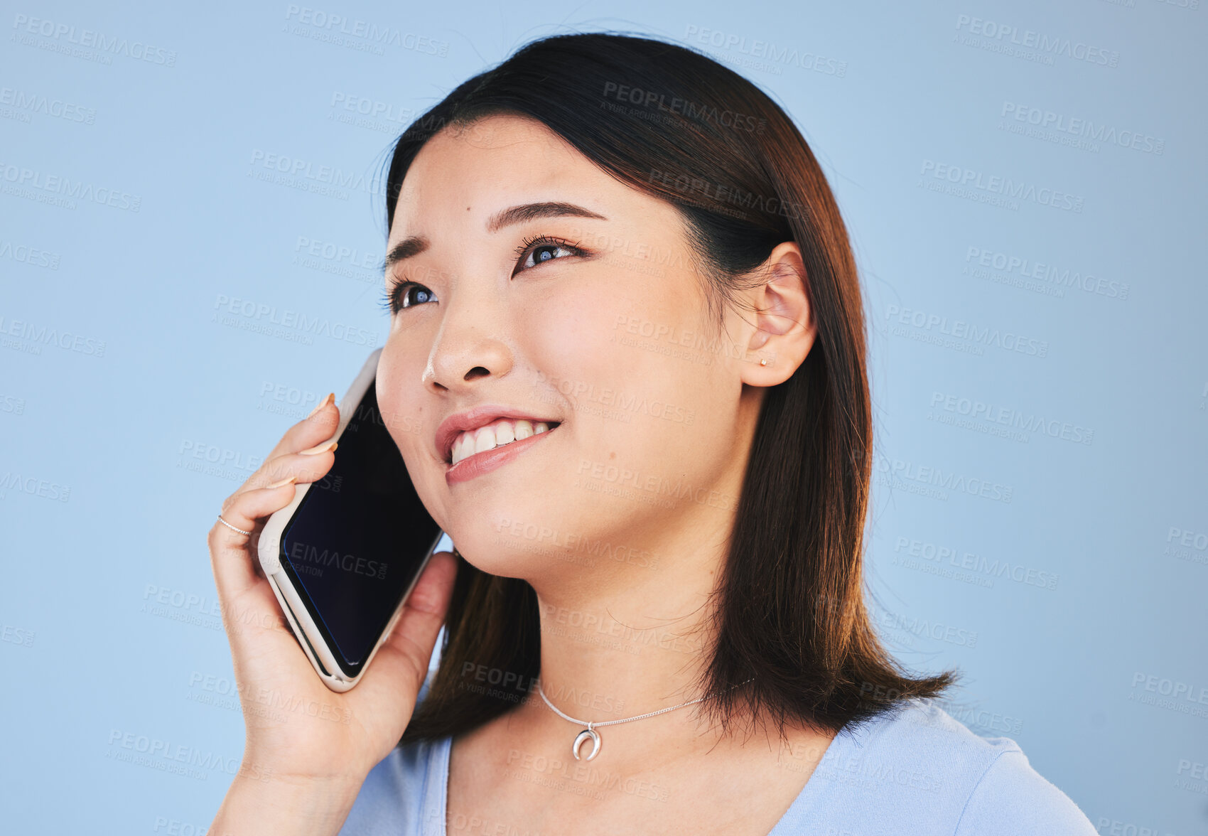 Buy stock photo Asian woman, thinking and phone call in studio with chat, networking and smile by blue background. Young Japanese student, girl and smartphone for contact, mobile connection and memory with ideas