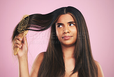 Buy stock photo Woman, hair and worry with brush in studio for texture, shine and keratin on pink background. Natural beauty, face and young model thinking with comb tools for tangled hairstyle, knot and treatment 