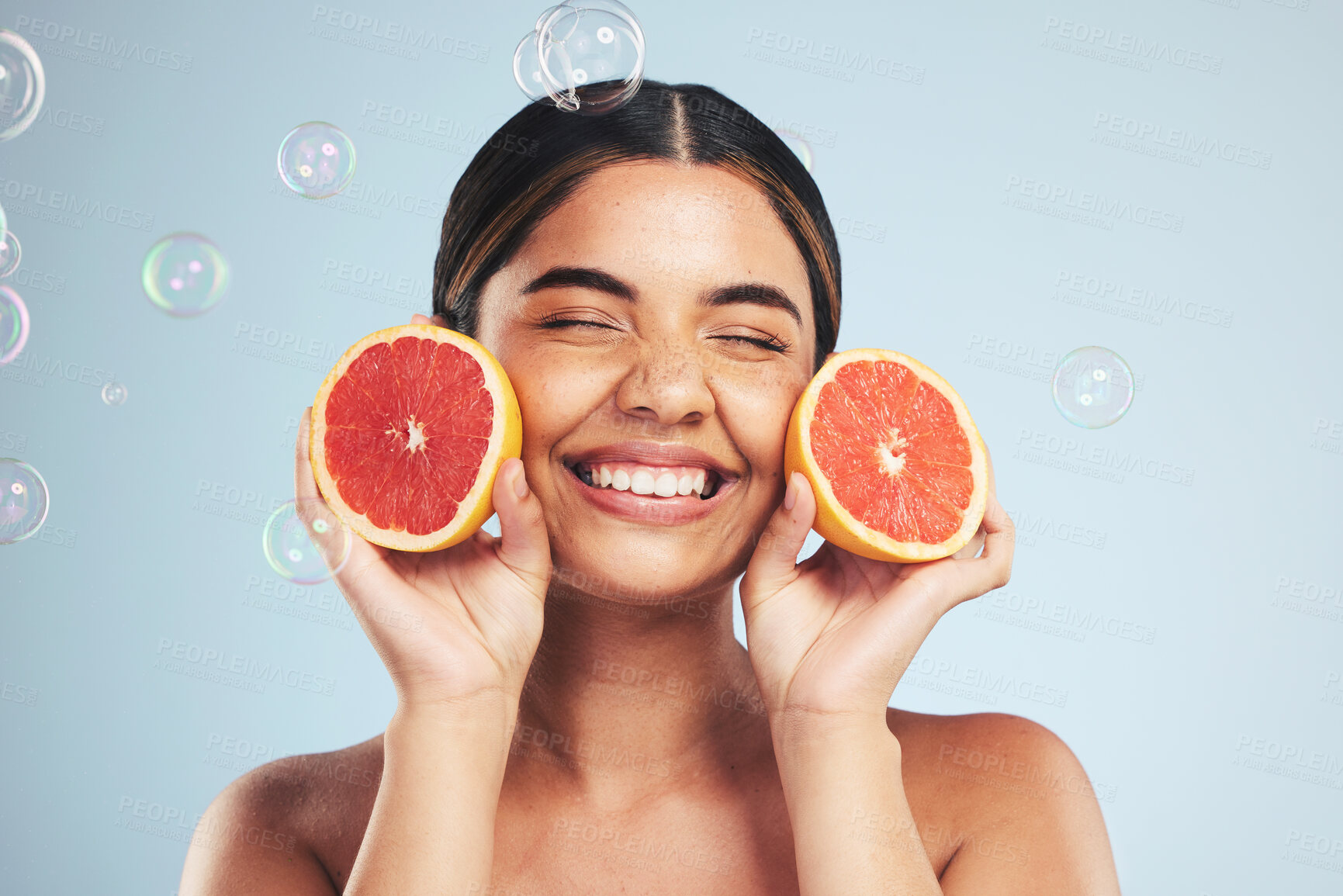 Buy stock photo Smile, woman and grapefruit skincare in studio for natural, cosmetic or wellness on grey background. Beauty, happy and model face with citrus facial, fruit or vitamin c, collagen and bubble aesthetic