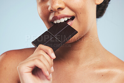 Buy stock photo Eating, chocolate and woman in studio with unhealthy, diet or luxury snack on blue background. Sugar, bite and lady model with cocoa candy bar craving, addiction or sweet satisfaction while isolated