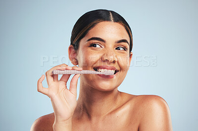 Buy stock photo Woman, happy and brushing teeth in studio for healthy dental wellness on blue background. Face of model thinking with toothbrush while cleaning mouth for fresh breath, oral hygiene or care of smile