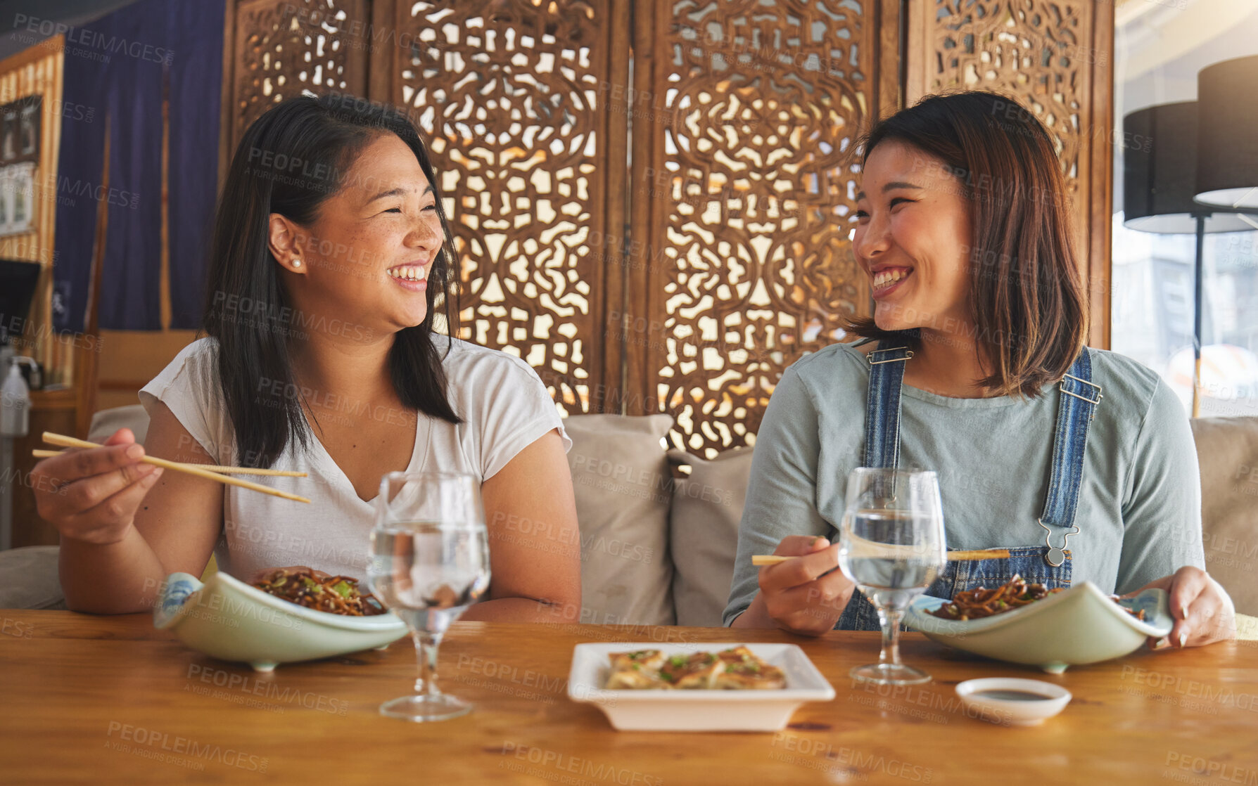 Buy stock photo Restaurant, girl friends and laughing with food, noodles and cafe happy from bonding. Asian women, eating and plate together with friendship smile at a table hungry with chopsticks at Japanese bar