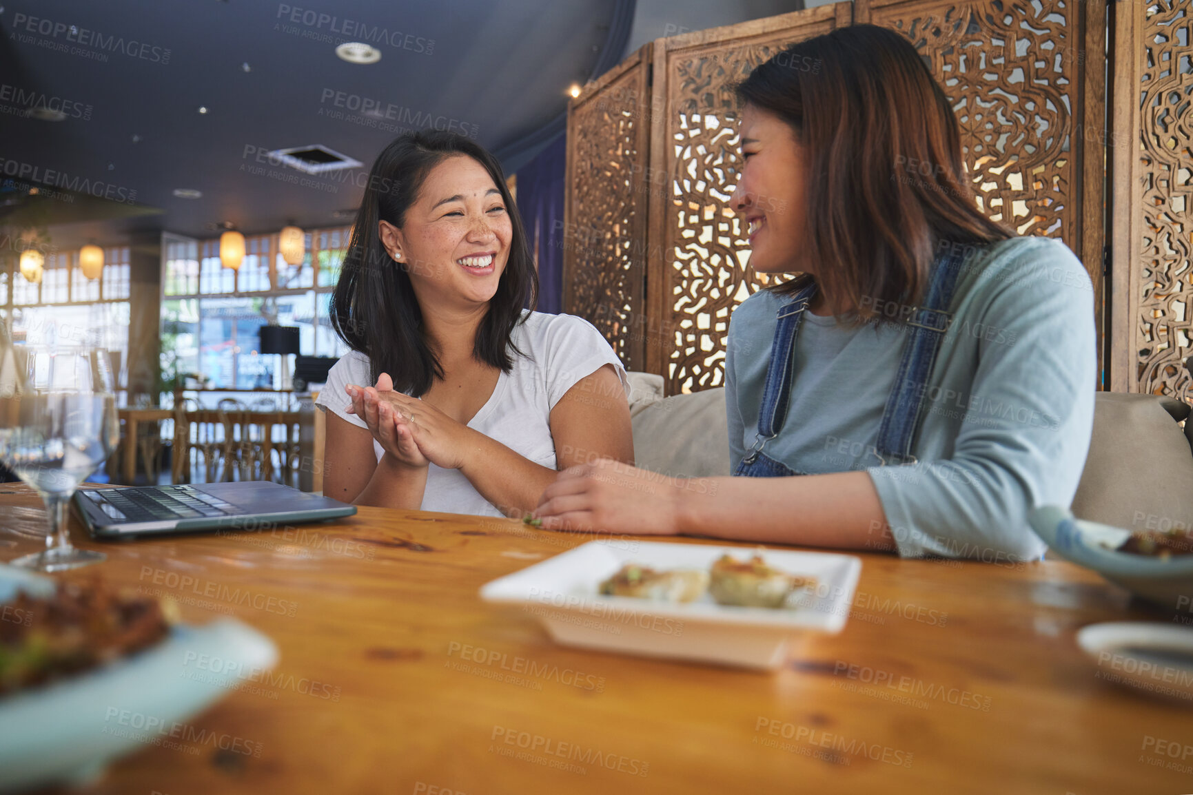 Buy stock photo Girl friends, sushi restaurant and eating with smile, comic chat or joke at meeting, laptop and table. Japanese students, happy and together for fish, seafood or diner with plate, talking or memory