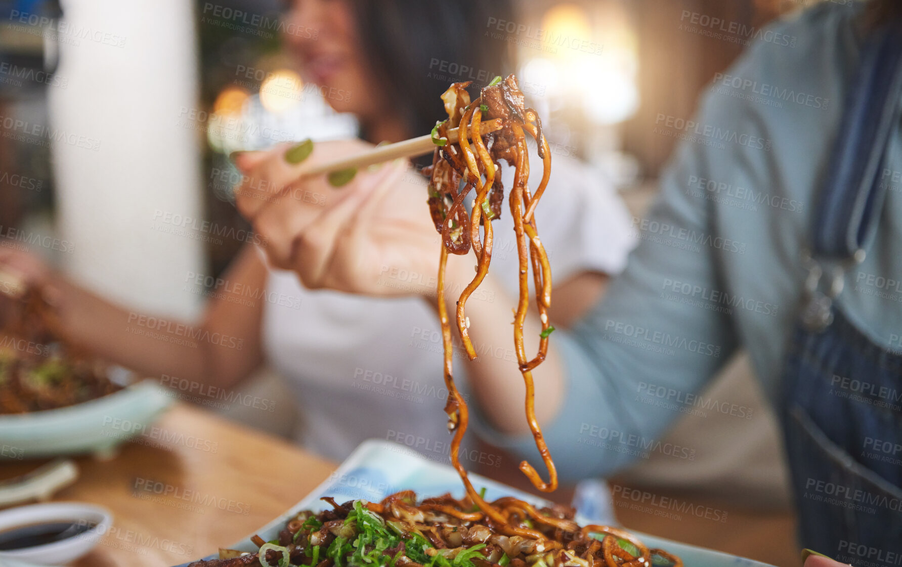 Buy stock photo Food, woman and hand with chopsticks in restaurant eat spaghetti and snack alone at table in closeup bokeh. Supper, person and meal, noodles on plate for lunch or asian dinner for nutrition