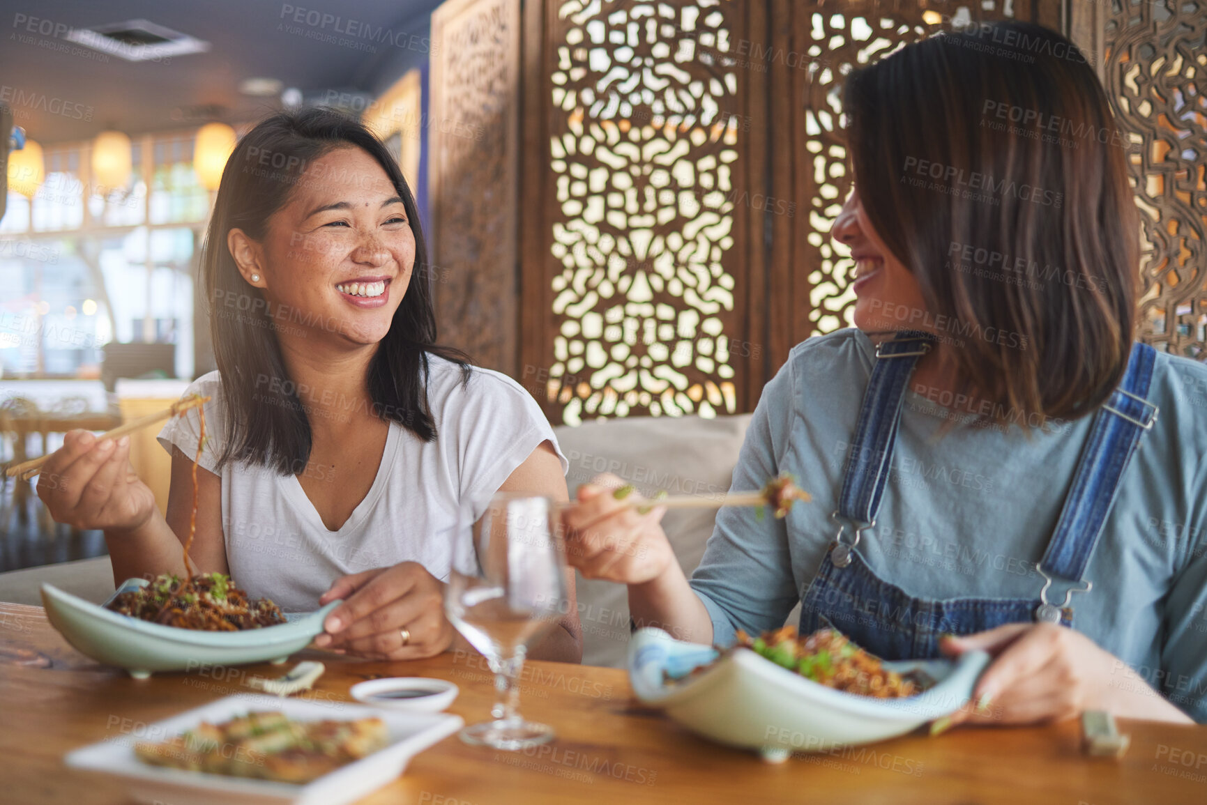 Buy stock photo Chopsticks, girl friends and funny joke with restaurant food, noodles and cafe happy from bonding. Asian women, eating and plate together with smile at a table hungry with lunch at Japanese bar