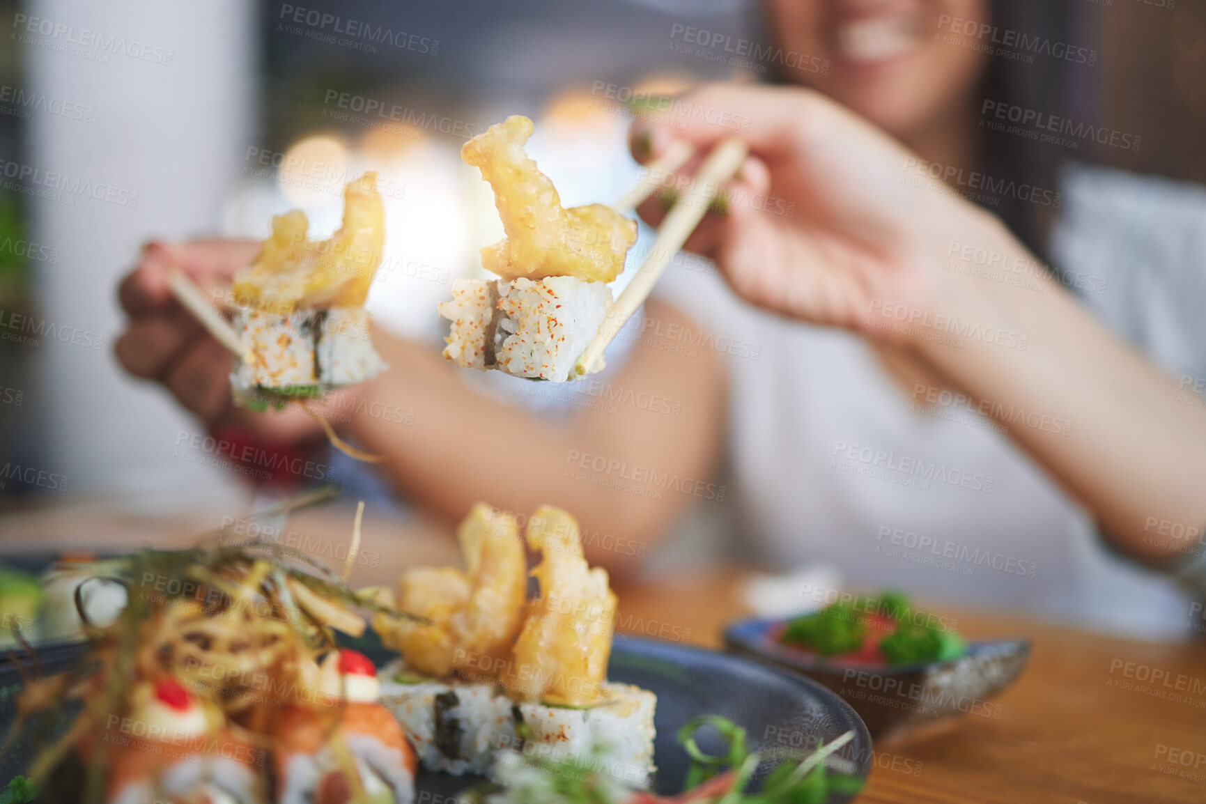 Buy stock photo Chopsticks, girl friends hands and shrimp sushi at a table  with Japanese cuisine food at restaurant. Young women, eating and tempura prawn with fish for lunch and meal on a plate with a smile