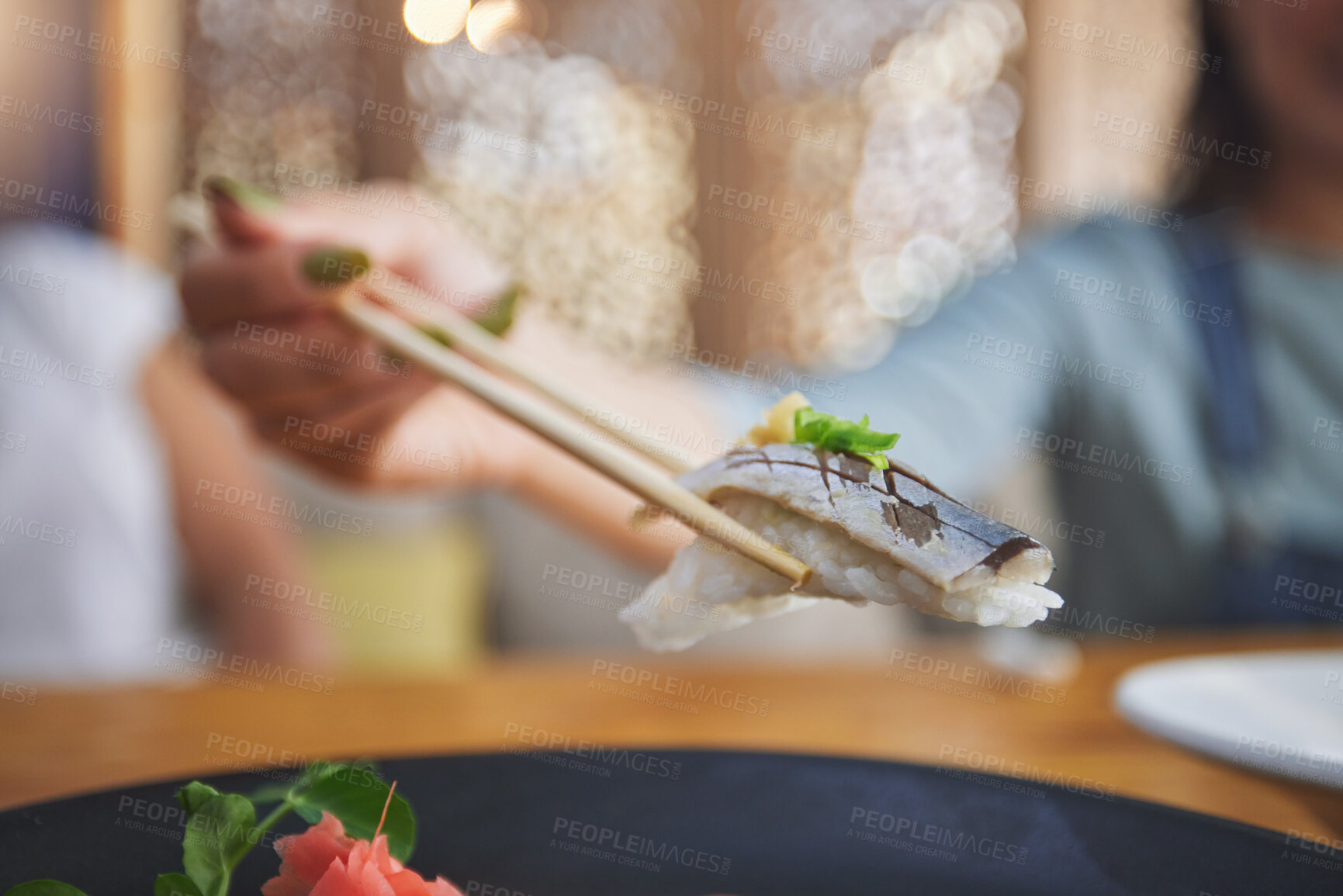 Buy stock photo Food, hand and eating sushi with chopsticks at restaurant for nutrition and health. Closeup of a hungry person with wooden sticks for dining, Japanese culture and cuisine with creativity on fish