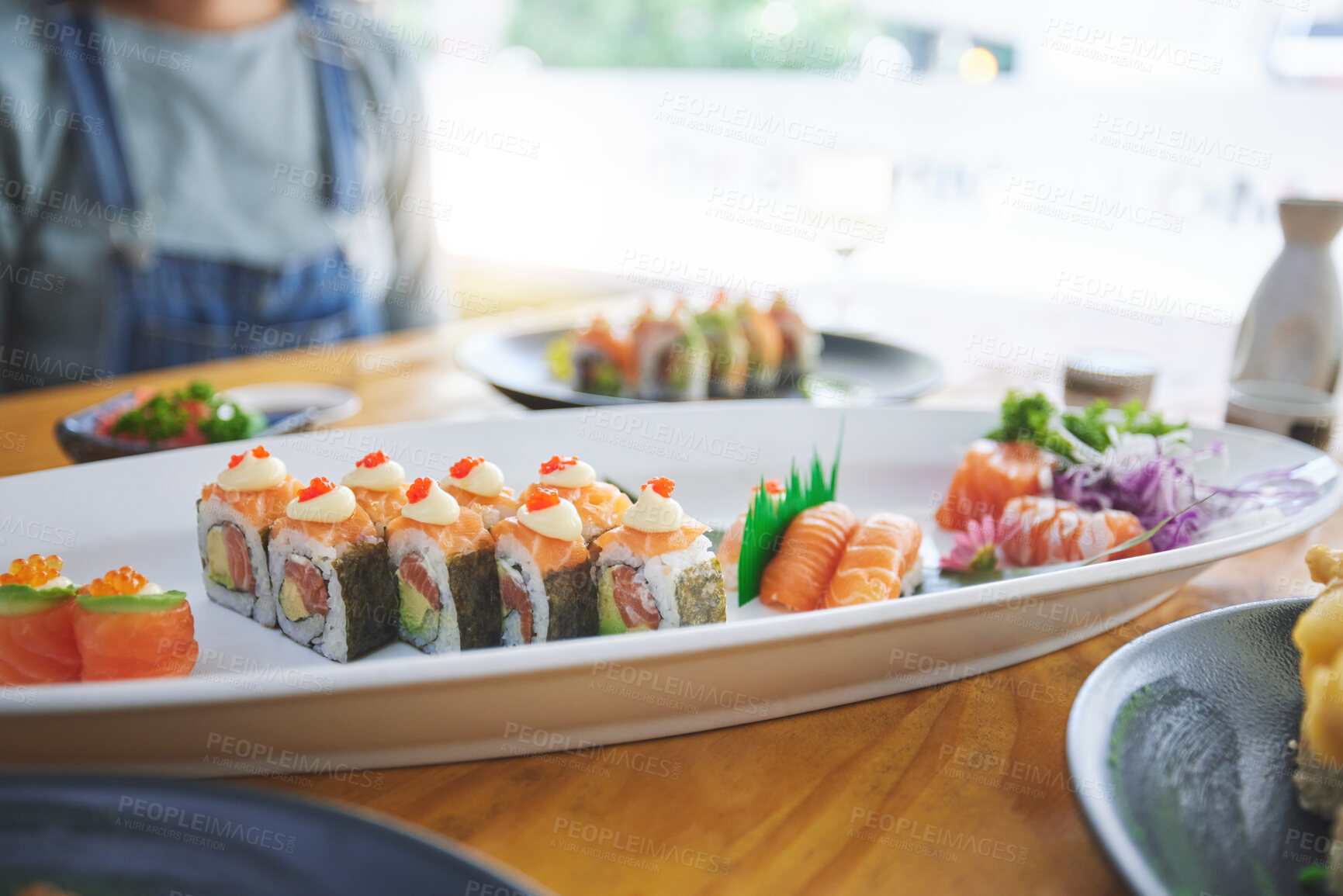 Buy stock photo Asian, sushi and luxury food at a restaurant for dinner or lunch meal at a healthy Japanese cafe on table. Plate, cuisine and fine dining takeaway or seafood from a Salmon menu for diet or nutrition